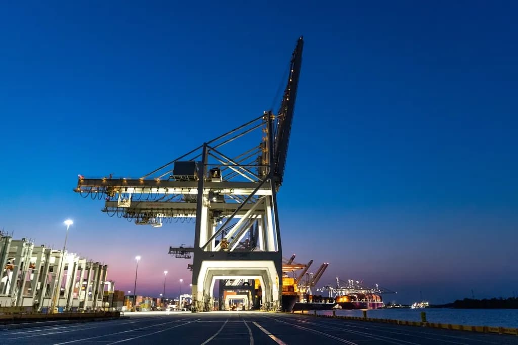 Container port with ship-to-shore cranes at dusk